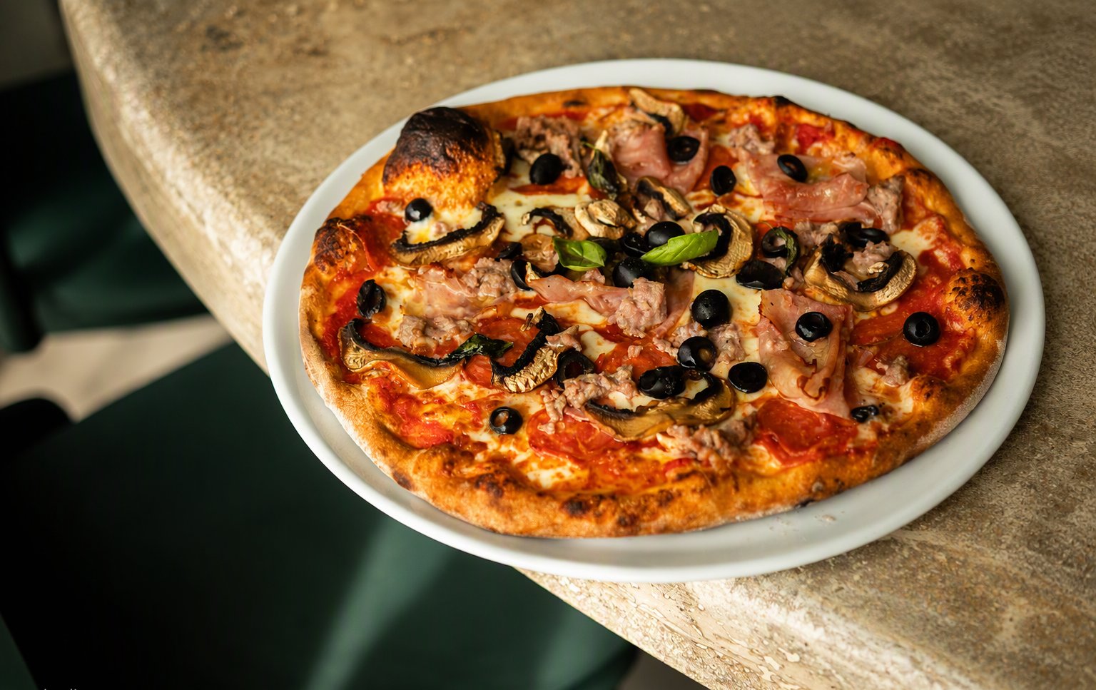 La pizza prosciutto e funghi dal forno a legna